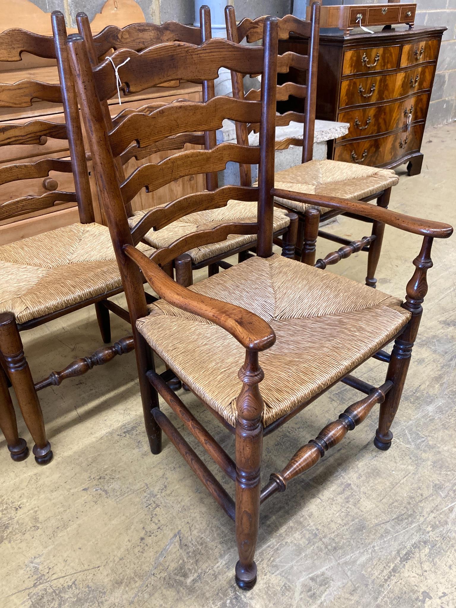 A set of five Lancashire ash and beech rush-seat ladderback chairs (one with arms)